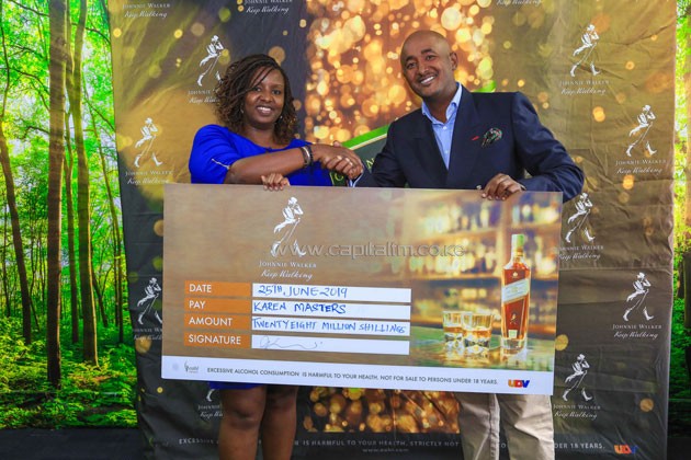 KBL Head of Spirits AnnJoy Muhoro (L) hands over a ceremonial cheque to Karen Country Club’s Ali Mohammed during the Karen Masters sponsorship unveil.